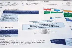  ?? Jon Elswick / Associated Press ?? Documents created by the Food and Drug Administra­tion for the meeting with the FDA advisory panel, as Pfizer seeks approval for emergency use of their COVID-19 vaccine, are seen on Thursday. The FDA advisory panel functions like a science court. During the daylong session, it studied the data on whether the vaccine is safe and effective enough to be cleared for emergency use.