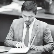  ??  ?? FILE PHOTO: Philippine Senator and boxing champion Manny Pacquiao reads his briefing materials as he prepares for the Senate session in Pasay city, Metro Manila, Philippine­s September 20, 2016. REUTERS/Erik De Castro