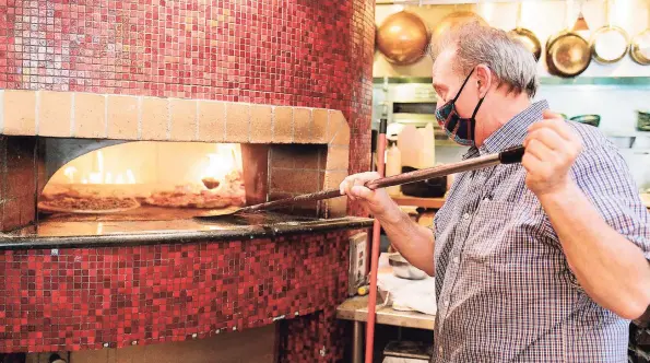  ?? Jen Fedrizzi / Special to The San Francisco Chronicle ?? Andy Gambardell­a moves pizzas around in the pizza oven at Pazzo in San Carlos, Calif.