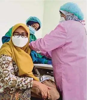  ?? AFP PIC ?? A woman receiving a Covid-19 vaccine shot at the Depok regional hospital in Depok, West Java yesterday.