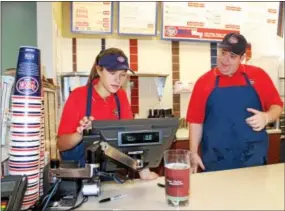  ?? BRIAN MCCULLOUGH — DIGITAL FIRST MEDIA ?? Jersey Mike’s Subs counter workers Meggie Wolfe and Joe Brennen check an order recently at the chain’s newest location in West Chester.