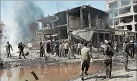  ?? DELIL SOULEIMAN/GETTY ?? Residents of the predominan­tly Kurdish town of Qamishli gather at the site of Wednesday’s bombing. Kurdish forces have been fighting Islamic State in northern Syria.