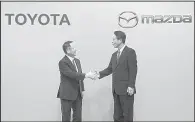  ?? AP/EUGENE HOSHIKO ?? Toyota Motor Corp. President Akio Toyoda (left) and Mazda Motor Corp. President Masamichi Kogai end a news conference Friday in Tokyo where Toyoda said automakers now have to compete with “totally new players like Google and Amazon.