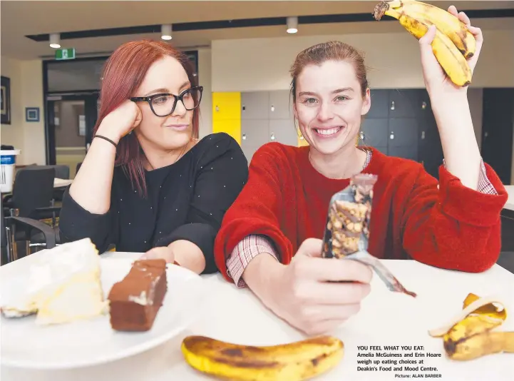  ?? Picture: ALAN BARBER ?? YOU FEEL WHAT YOU EAT: Amelia McGuiness and Erin Hoare weigh up eating choices at Deakin's Food and Mood Centre.