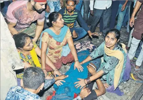  ?? SAMEER SEHGAL/HT ?? ■ MOURNING THE DEAD: Relatives crying near the body of a young victim at the accident site at Jaura Phatak in Amritsar on Friday; and (left) an inconsolab­le woman grieving over the loss of her brother.