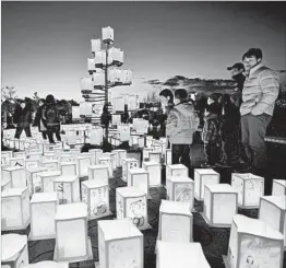  ?? KAZUHIRO NOGI/GETTY-AFP ?? Visitors attend a memorial service Saturday for the victims of the 2011 tsunami in Japan.