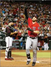  ?? ASSOCIATED PRESS ?? WASHINGTON NATIONALS’ BRYCE HARPER (right) celebrates his home run as Arizona Diamondbac­ks’ Chris Iannetta (left) stands at home plate during the first inning of Saturday’s game in Phoenix.