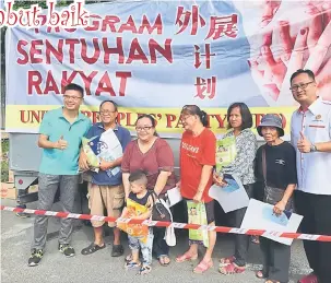  ??  ?? RINGANKAN BEBAN: Wong (kiri) dan Ting (kanan) merakam kenangan bersama penduduk Kampung Sentosa pada Program Sentuhan Rakyat.