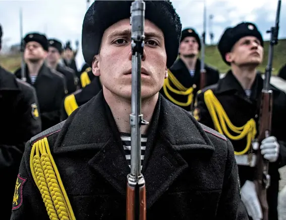  ??  ?? CRIMEA AND PUNISHMENT: Crimea’s honor guard celebrates Russia’s annexation of the peninsula. Western critics sparred with pro-russian activists online about Moscow’s takeover.