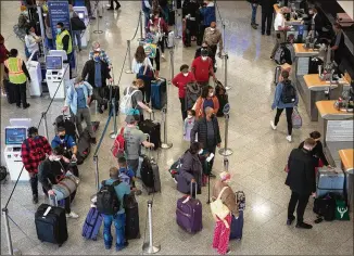  ?? STEVE SCHAEFER FOR THE AJC ?? Passengers are backed up at the Delta check-in at Hartsfield-Jackson Internatio­nal Airport last week. Atlanta-based Delta scrubbed more than 100 flights Saturday.