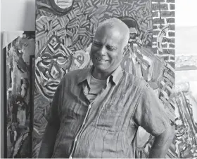  ?? Liz Moughon / The Chronicle ?? Artist Charles Curtis Blackwell poses in front of several of his paintings at his Oakland home.