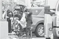  ?? — Gambar AFP ?? BANTU: Anggota polis membantu salah seorang mangsa selepas seorang lelaki bersenjata melepaskan tembakan di King Sooper’s Grocery di Boulder, Colorado kelmarin.