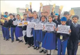  ??  ?? School students carrying playcards with an appeal to the chief minister to relocate the Bhagtanwal­a garbage dump on the outskirts of Amritsar on Wednesday. HT PHOTO