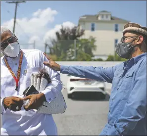  ?? (AP/Jessie Wardarski) ?? Abdul Latif Balanta (left), and Mansoor Shams joke with each other after Friday prayer in Rosedale, Md. In recent years, Shams has used his identity as both a Muslim and a former Marine to dispel misconcept­ions about Islam.