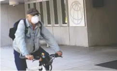  ?? SAUL LOEB / AFP via Gett
y Imag
es ?? A man rides a bicycle past the headquarte­rs of the World Bank Group in Washington, D.C., last month.