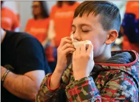  ??  ?? Jacob Weikert, 11, of Bethlehem, namesake of Team Jacob, grabs a chicken wing during the contest. Jacob received therapy for autism through Easterseal­s.
