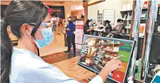  ??  ?? An AllDay customer uses the self-checkout counter to pay for her grocery items at AllDay EVIA Lifestyle branch.