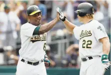 ?? Jed Jacobsohn / Getty Images 2003 ?? Jose Guillén (left), with A’s teammate Eric Byrnes in 2003, had an outfield arm that one teammate thinks was the best ever.