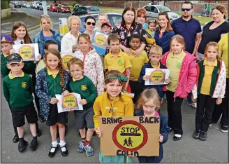  ??  ?? Support: Parents and children campaignin­g for the lollipop man’s return