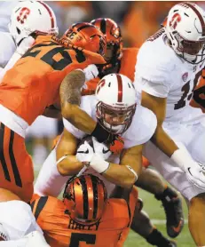  ?? Timothy J. Gonzalez / Associated Press ?? Christian McCaffrey (center) plows for a portion of his 206 rushing yards against Devin Chappell (left) and Kyle Haley.