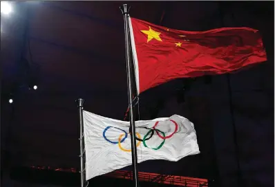  ?? (AP/Natacha Pisarenko) ?? The Chinese and Olympic flags fly Friday during the opening ceremony.