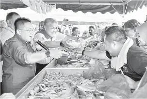  ?? —Gambar Bernama ?? BELI IKAN: Zahid melelong ikan segar di gerai Lembaga Kemajuan Ikan Malaysia (LKIM) ketika beliau melawat tapak pameran selepas merasmikan Fiesta Strategi Lautan Biru Kebangsaan (NBOS) Sayang Malaysia di Padang Sekolah Menengah Kebangsaan Hutan...