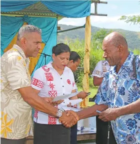  ?? Photo: DEPTFO News ?? Minister for Industry, Trade, Tourism, Lands and Mineral Resources Faiyaz Koya (left) hands over a cheque to a recipient during the 2017-2018 Micro Small Business Grant (MSBG) disburseme­nt by Government in Rakiraki on June 14, 2018.