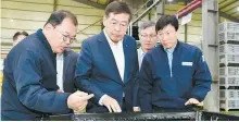  ?? Courtesy of LG Chem ?? LG Chem CEO Shin Hak-cheol, center, takes a look at its partner company’s product.