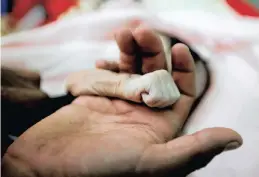  ??  ?? SALEH Haassan Al-Faqeh holds the hand of his 4-month-old daughter, Hajar, who died in the malnutriti­on ward of al-Sabeen hospital in Sanaa, Yemen, last month.Reuters African