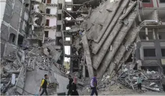  ?? ?? Des Palestinie­ns dans les décombres de Gaza city, le 24 novembre 2023.