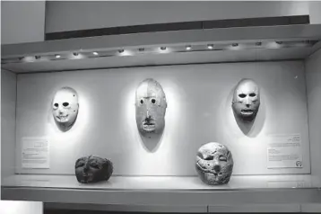  ?? MAYA ALLERUZZO/AP ?? A Neolithic mask loaned by American billionair­e Michael Steinhardt, center, is displayed at the Israel Museum in Jerusalem. The artifact was among 180 recently surrendere­d by Steinhardt to avoid prosecutio­n in the United States.