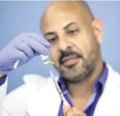  ?? AL DIAZ adiaz@miamiheral­d.com ?? Nurse practition­er Joel Ramos prepares a dose of the monkeypox vaccine for a patient at Latinos Salud in Wilton Manors on Wednesday.