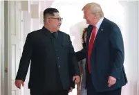  ?? (Reuters) ?? US PRESIDENT Donald Trump walks with North Korean leader Kim Jong Un on Tuesday at the Capella Hotel on Sentosa Island in Singapore, in this picture from the Korean Central News Agency.