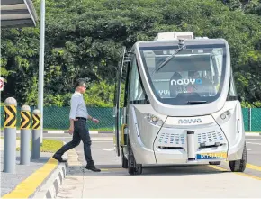  ??  ?? LEFT An engineer boards a Navya autonomous electric passenger bus travelling along the Cetran test circuit in Singapore.