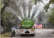  ?? — PTI ?? A tanker sprays water to curb rising pollution at Gautam Puri in New Delhi on Tuesday.