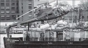  ?? AP PHOTO ?? A helicopter is hoisted by crane from the East River onto a barge Monday in New York.
