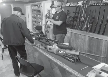  ?? Ap Photo/the daily Sentinel, andrew d. brosig ?? Clerk Lance McCoy, right, shows a variety of weapons including an AR-15-style semi-automatic at Kizer Guns and Ammo near Nacogdoche­s, Texas. Demand for firearms, ammunition and bulletproo­f gear has jumped since the Dec. 14 school shooting in Newtown,...