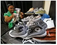  ?? TY GREENLEES / STAFF ?? Trotwood parent engagement team member Chaunta Bennett sorts donated shoes that will be available at the district’s Back to School Bash.