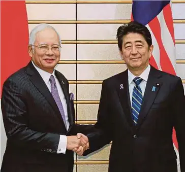  ??  ?? Japanese Prime Minister Shinzo Abe greeting Prime Minister Datuk Seri Najib Razak at the start of their bilateral talks at the latter’s official residence in Tokyo on Wednesday. EPA pic