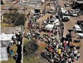  ?? JEROME DELAY/AP ?? Thousands line up to receive food handouts Saturday in the Olievenhou­tbos township of Midrand, South Africa.