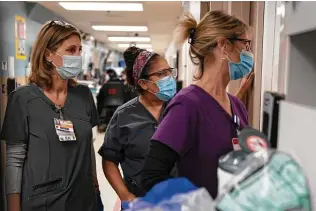  ?? Jae C. Hong / Associated Press ?? Nurse Kristina Shannon, from left, chaplain Andrea Cammarota and nurse Cathy Carter watch as medical workers try to resuscitat­e a coronaviru­s patient at a Los Angeles hospital Thursday.