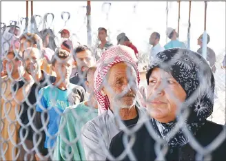  ??  ?? Displaced Syrians queue at a Kurdish controlled checkpoint between the rebel-held town of Azaz in northern Syria
and the city of Afrin, along Syria’s northern border with Turkey, as they attempt to cross on June 9. (AFP)