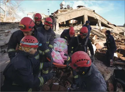  ?? ?? The Associated Press
Rescue teams evacuate a survivor from the rubble of a destroyed building in Kahramanma­ras, southern Turkey on Tuesday. The death toll from the giant earthquake was at 7,200, but expected to rise.