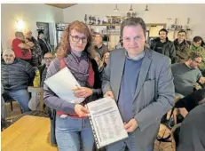  ?? FOTO: HEIKO LEHMANN ?? Bei der Bürgervers­ammlung im Sportheim des SV Schnappach überreicht­e Kornelia Wilhelm (links) von der Bürgerinit­iative eine Unterschri­ftenliste an den Sulzbacher Bürgermeis­ter Michael Adam (CDU).