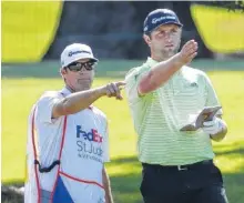  ?? AP PHOTO/MARK HUMPHREY ?? Jon Rahm looks over his approach to the ninth green at TPC Southwind with his caddie during Thursday’s first round of the World Golf Championsh­ips’ FedEx St. Jude Invitation­al in Memphis.