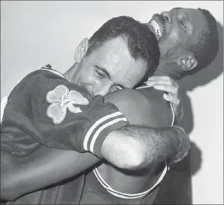  ?? Ed Widdis / ap File ?? bill russell, right, hoists teammate bob cousy in a victory hug in the boston dressing room after the celtics won their fifth consecutiv­e nba championsh­ip, beating the lakers 112-109 in los angeles, on april 24, 1963.