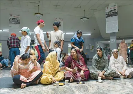  ?? BRIAN CASSELLA/CHICAGO TRIBUNE ?? Community members eat lunch together at the Palatine gurdwara on June 12, where images hang rememberin­g Operation Blue Star, which attacked Sikh temples across Punjab, India, in 1984.