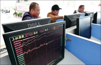  ?? LU QIJIAN / FOR CHINA DAILY ?? Investors check share prices at a brokerage in Fuyang, Anhui province, on Friday.