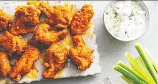  ?? SCOTT SUCHMAN/FOR THE WASHINGTON POST ?? Delightful­ly crispy wings start with a starchy coating.
