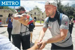  ?? Billy Calzada / San Antonio Express-News ?? Walking With the Wounded participan­t Kev Carr (right), a veteran of the British Royal Logistic Corps, is greeted by a supporter in front of the Alamo.